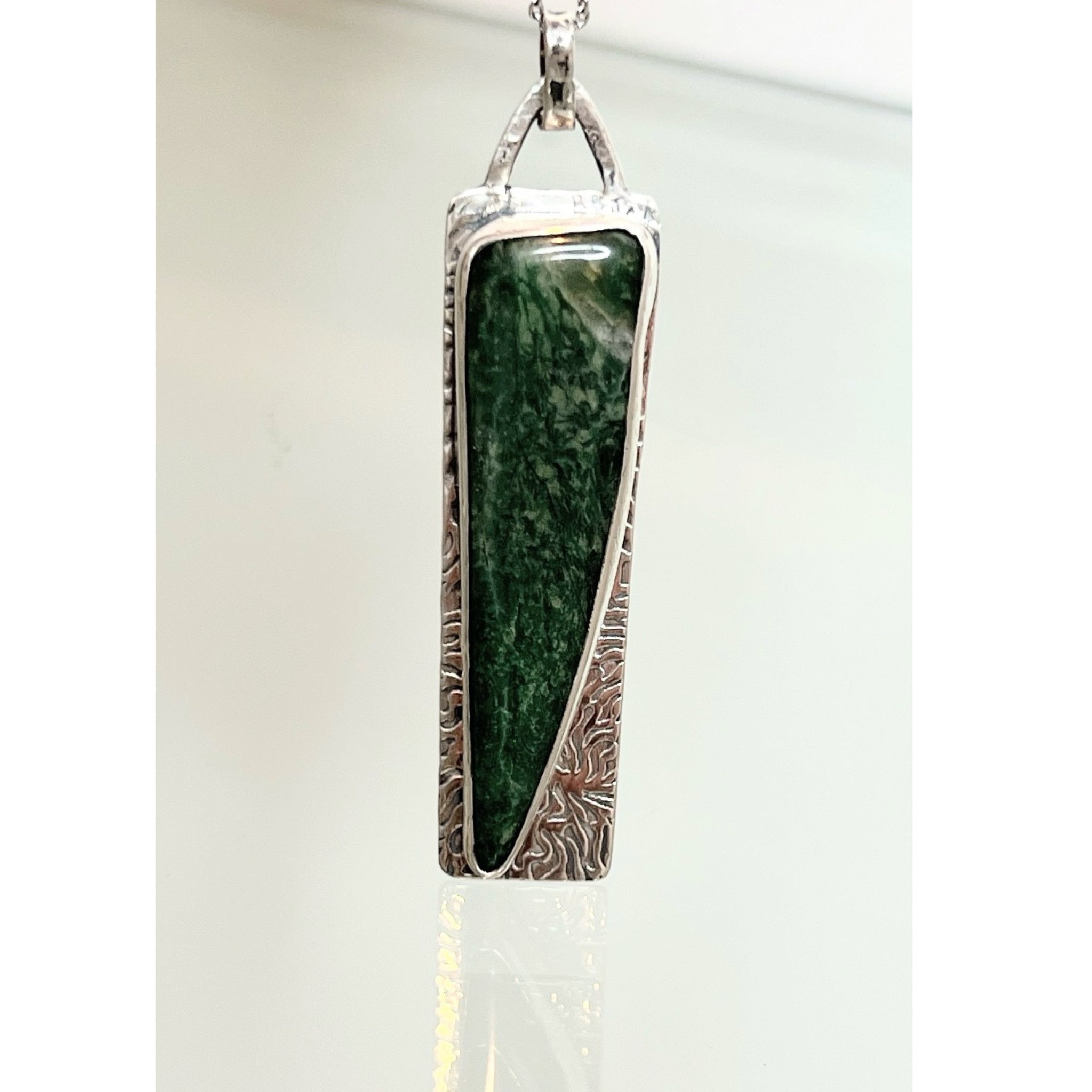 Oxidized sterling silver pendant with forest green stone - on white, glass like background