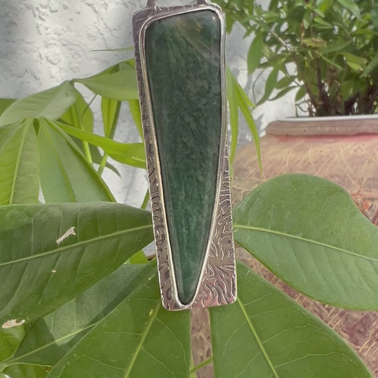 "Close-up life view of forest green semi-precious stone silver pendant artisan crafted"