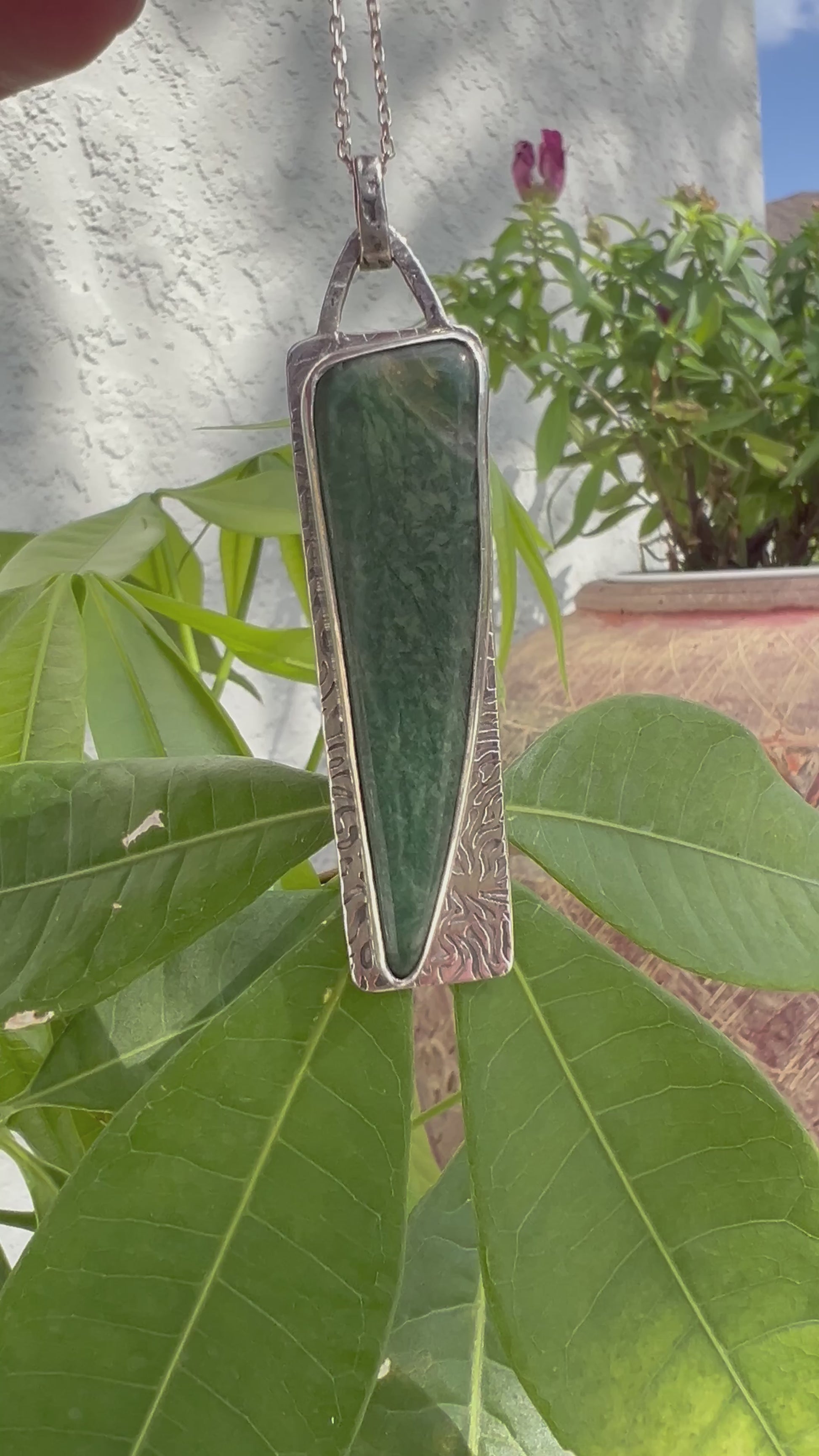 "Close-up life view of forest green semi-precious stone silver pendant artisan crafted"