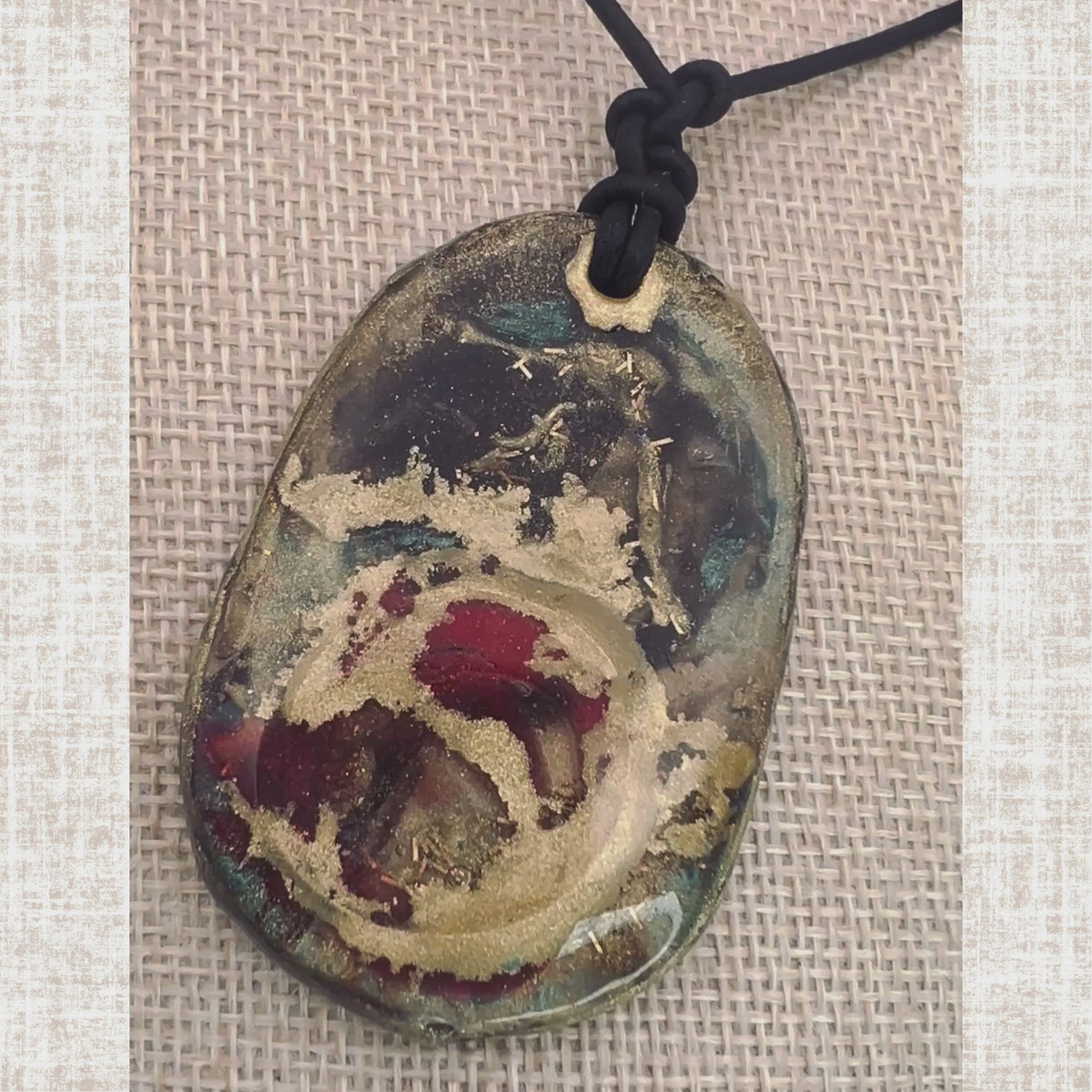 Short video showcasing the UV resin pendant necklace with gold, red, and brown inclusions — glossy 3D resin finish catching light, displayed on leather cord.